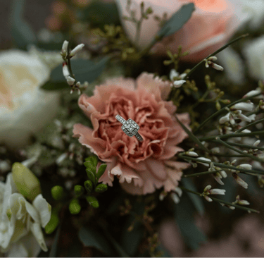 une fleur rose pêche avec une bague argent au centre