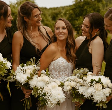 Une mariée en robe blanche souriant à ses demoiselles d'honneur