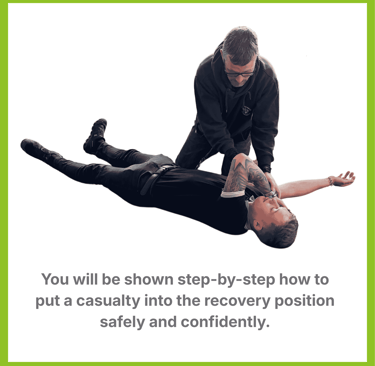 A man places another man in the recovery position after an emergency.