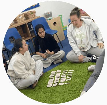 a group of learners sat on the floor completing an exercise using cards