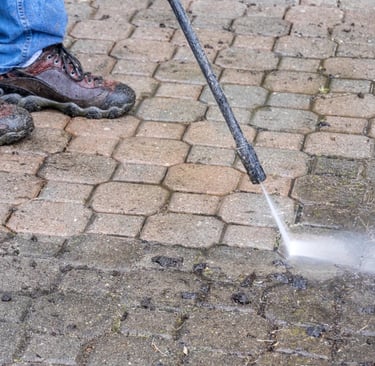 Nettoyage de terrasse avec jet haute pression à Spa, partie déjà nettoyée visible à l’arrière-plan.