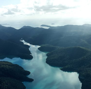 Aerial view of lush green tropical islands and turquoise ocean water in a scenic coastal landscape.