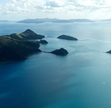 Aerial view of tropical islands and blue ocean water in the Whitsundays, Australia.