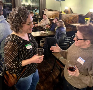 two women speaking at a bar
