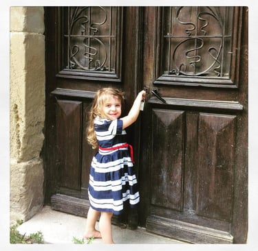A young girl knocking at an old door
