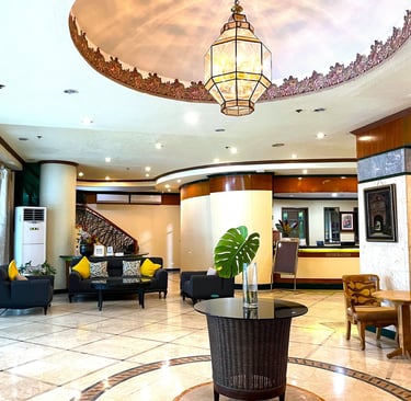 a lobby area with a large circular table and chairs