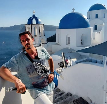 Turista en Santorini, Grecia, con vistas a las icónicas cúpulas azules y edificios blancos sobre el 