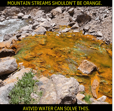 Polluted orange mountain water stream.