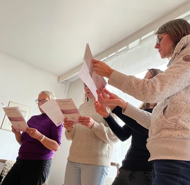 eine Gruppe von Sängern bei der Chorprobe mit Notenblättern in der Hand