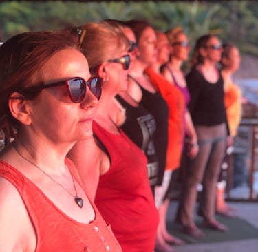 A group of women stand looking out to sea with a calm presence