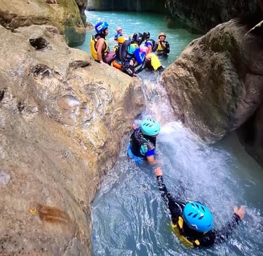 a group of people in helmets canyoneering