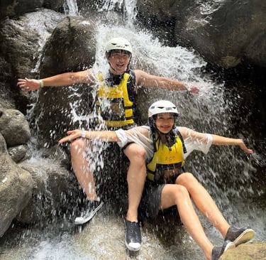 a man and woman sitting on a waterfall in a river