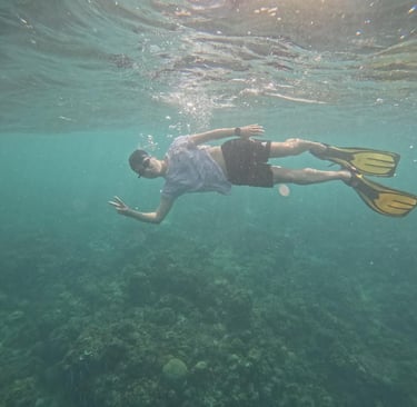 a man swimming in the ocean with a scuba diver