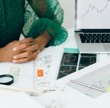 Uma mulher em sua mesa de trabalho com seu computador e materiais de métricas