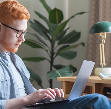 a man sitting in a chair with a laptop computer