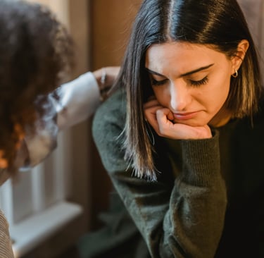 femme qui pose sa main sur l'épaule d'une adolescente