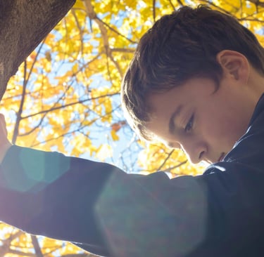 enfant de 10 ans s'appuyant sur un arbre