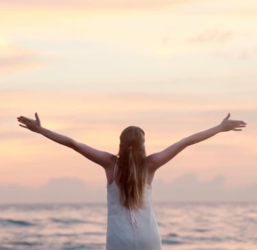 una mujer con brazos abiertos mirando al horizonte