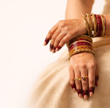 Lac Chudi red and gold lac bangles worn on hands with mehndi for Indian bridal and festive occasions