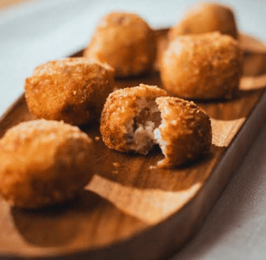 Croquetas caseras recién fritas, especialidad del restaurante elaborada con receta tradicional.