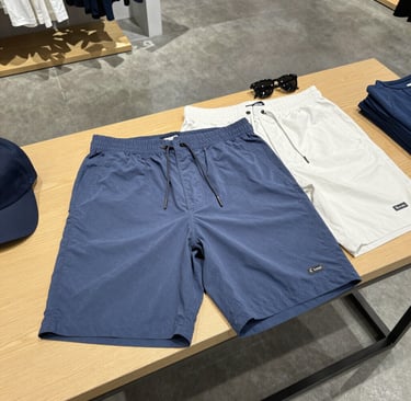 A stylish pair of capris displayed on a wooden bench with sunlight filtering through leaves.