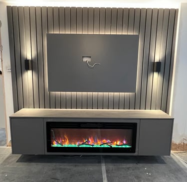 Modern media wall with a mounted TV area, built-in electric fireplace, and LED accent lighting on a ribbed panel background.