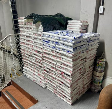Stacks of white plastic sacks filled with materials in a storage area or warehouse.