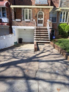 Front yard with covered porch, enclosed garage and private driveway.