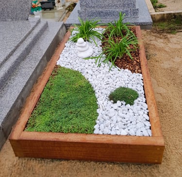 Monument funéraire végétalisé avec cadre en bois, chemin de galets blancs zen, tapis de mousse verte