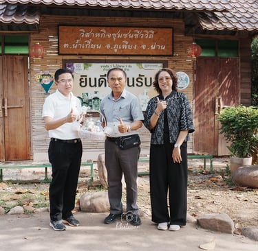 กลุ่มบุคคลถ่ายภาพหน้าป้ายชุมชนบ้านน้ำเกี๋ยน อำเภอภูเพียง จังหวัดน่าน บรรยากาศอบอุ่น วิถีชีวิตท้องถิ่