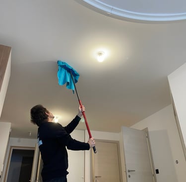 Agent d’entretien, nettoyage plafond avec un balais brosse rouge 