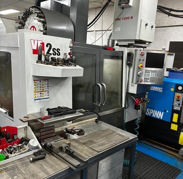 Haas VF-2ss CNC vertical machining center in a precision machine shop with industrial tooling and equipment.