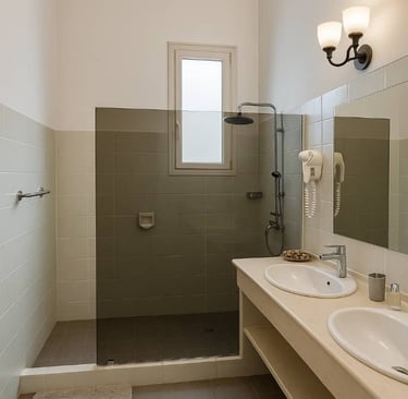 Modern bathroom with double vanity, walk-in tile shower, and glass partition.