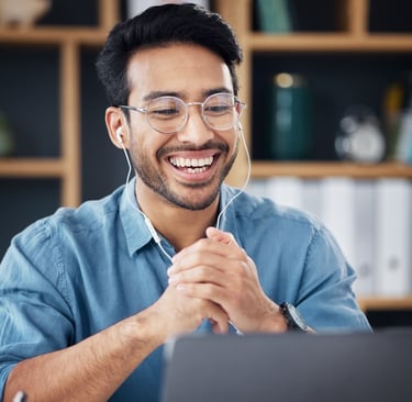 a man with glasses and headphones on his laptop