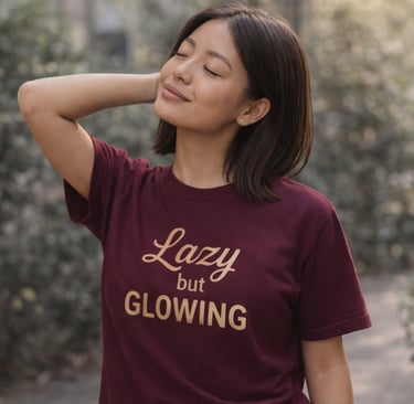 Frau mit maroon „Lazy but Glowing“ Shirt steht entspannt draußen. Symbol für bewusst langsamer leben