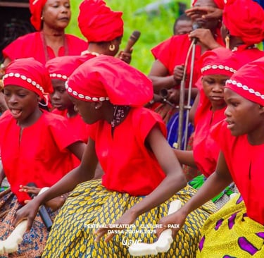 Young girls in red traditional attire performing at the Festival Createur Culture Paix in Dassa-Zoume.