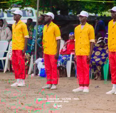 Performers in yellow shirts and red pants at the Festival Createur Culture Paix in Dassa-Zoume 2025.