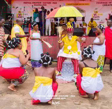 A traditional West African cultural ceremony in Dassa-Zoume featuring a seated King and dancers in tribal attire.