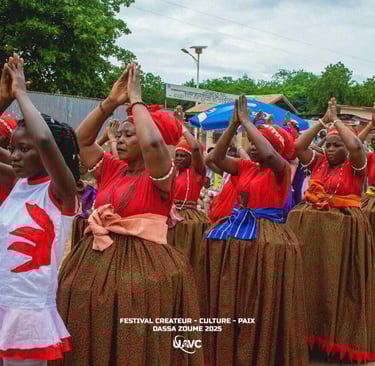 Beninese women perform a traditional dance in red and green cultural attire at the Dassa-Zoume 2025 festival.