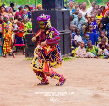 Egungun masquerade performing in colorful traditional costume at a Benin cultural festival in Dassa-Zoumé.