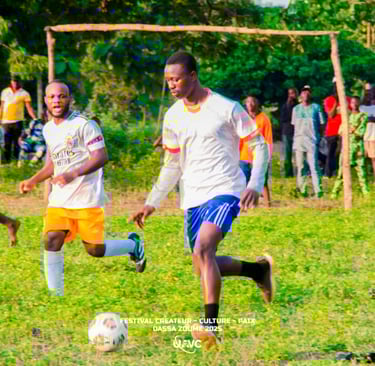 Young men playing soccer on a grassy field at the Festival Createur Culture Paix in Dassa-Zoume 2025.