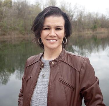 Amy Hale, paranormal romance author, standing outdoors near a lake