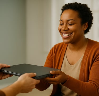 A smiling woman receives a refurbished laptop from Tech-Takeback Foundation