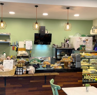 içi yumuşak yeşil tonunda boyanmış, doğal ışıkla aydınlanmış kafe 