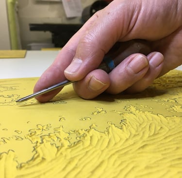 Phtographie de main gravant une plaque de linoléum