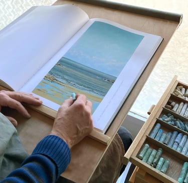 Photographie d'artiste en action pour faire un paysage au pastel sec. 