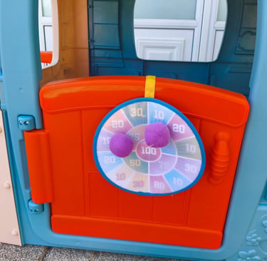 Análise do alvo de dardos com bolas de velcro na porta da casinha infantil Feber Casual House.