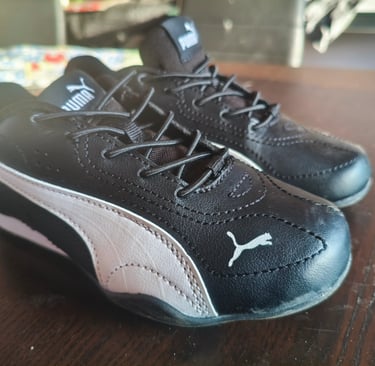 Sapatilhas infantis Puma Catch pretas com velcro e logo Puma em branco vistas de frente