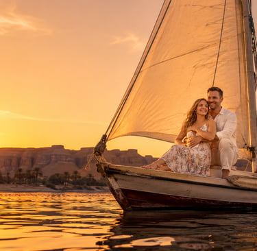 A couple enjoying a romantic sunset felucca boat ride on the Nile River in Luxor, Egypt.
