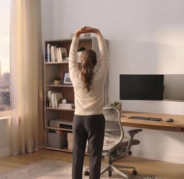 A professional woman stretches her arms upward in a minimalist office.